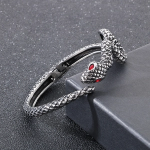 Detailed view of snake-shaped bracelet scales with red rhinestone eyes in vintage silver