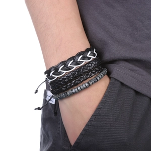 Gros plan de bracelets multicouches en cuir tressé avec perles et breloque carte d'Afrique