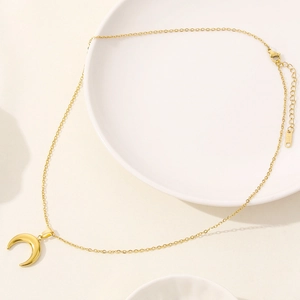 Dettaglio della collana a mezzaluna dorata con chiusura a moschettone e catenina regolabile