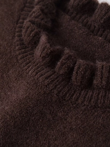 Detail shot of the ruffled neckline on a dark brown wool knit sweater with rich texture