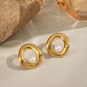 Elegant gold round pearl stud earrings for women presented on a minimalist stone base