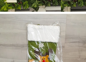 Détail d'une chaussette de Noël en tricot vert avec applique de renne et fourrure