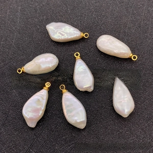 Macro detail of seven irregular baroque pearl pendants with gold-plated metal loops