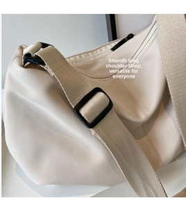 Detail of adjustable wide shoulder strap with black buckle on beige tote bag