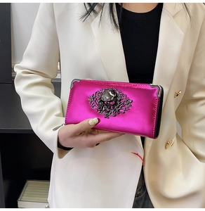 Pink long wallet with metallic finish featuring a skull ornament and metal corners