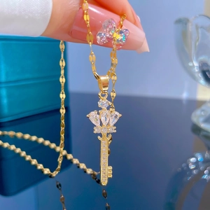 Gold crown key necklace featuring pear-shaped cubic zirconia stones on titanium steel chain