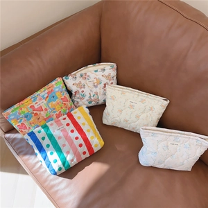 Detailed macro of quilted cotton makeup bags with floral patterns and zipper closure