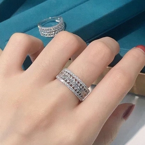 Detailed view of multilayer silver ring with round and baguette cut zircons on a model