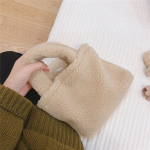 Gros plan du mini sac fourre-tout beige en polaire douce avec poignées en laine