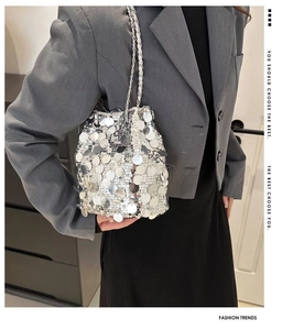Detail of silver sequin bucket bag featuring large scales and metallic chain strap