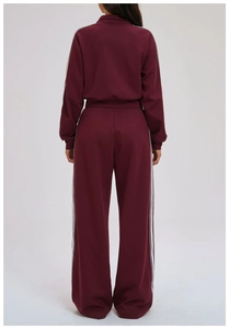 Back view of burgundy sports set with white side stripes and wide-leg trousers