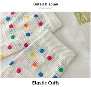 Detailed close-up of elastic ribbed cuff on white mesh socks with colorful polka dots