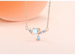 Macro shot of rose gold planet necklace featuring blue opal and teardrop pendant