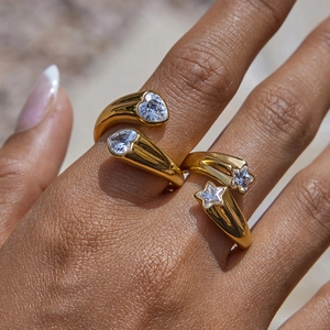 Anillos Toi et Moi dorados de acero con circonitas de corazón y estrella en la mano