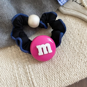 Détail macro d'un chouchou en tissu avec perle en résine m rose et perles blanches