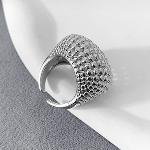 Makroaufnahme eines silbernen Rings mit Perlenstruktur und verstellbarem offenem Band