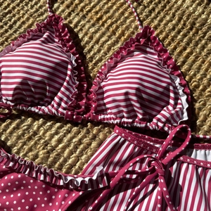 Bikini rouge et blanc à rayures et pois avec volants sur fond en toile de jute