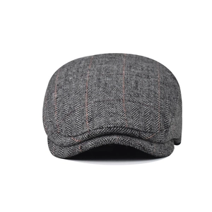 Close-up of retro grey herringbone flat cap with subtle red stripes and wool texture