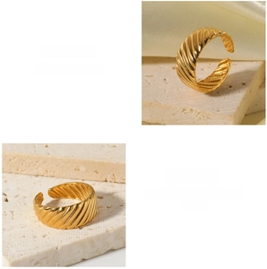 Macro detail of adjustable golden spiral twist ring on stone and silk background