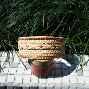Detailed texture of hand-woven beige and brown striped raffia straw headband in nature