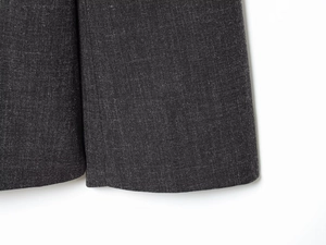 Macro shot of dark grey suit hem highlighting fine fabric texture and neat stitching details