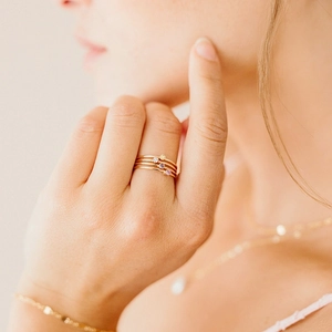Primer plano de anillos apilables de oro minimalistas con circonitas de colores