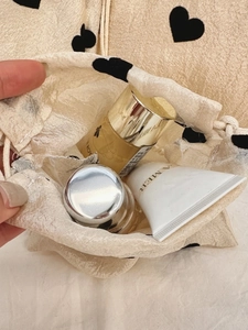 Champagne drawstring storage pouch with black heart pattern and satin finish