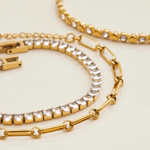 Gold-plated heart zircon tennis bracelet and paperclip chain set for women on white surface
