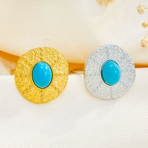 Close-up of gold and silver vintage rings with oval turquoise stones and beaded details
