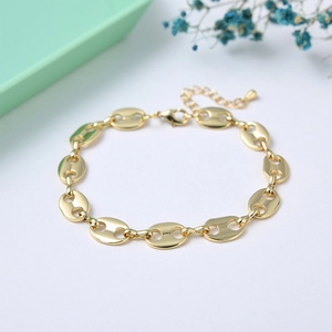 Golden pig nose link chain bracelet with freshwater pearls and lobster clasp on a tray