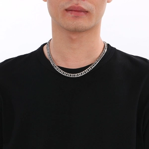 Gros plan d'un collier chaîne gourmette en acier inoxydable pour homme porté sur fond blanc