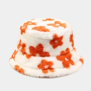 Close-up of fluffy faux fur bucket hat featuring orange flower pattern on white fabric