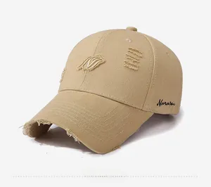 Close-up of distressed khaki cotton baseball cap with ripped edges and Marasen embroidery