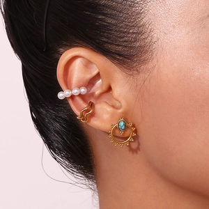 Bohemian gold turquoise stud and pearl ear cuff set on model ear in close-up view