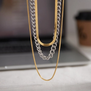 Close-up of three-layered necklace set with gold and silver toned mixed chains