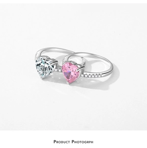 Detailed view of silver rings featuring heart-cut clear and pink stones with pavé band