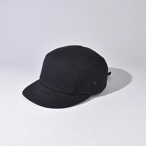 Detail view of a 5-panel black camping cap with metal side eyelets and plain fabric texture