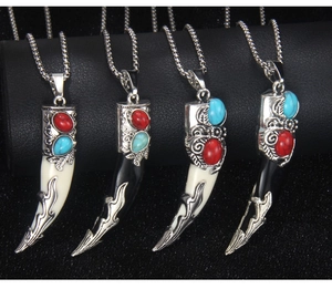 Detailed view of four retro wolf tooth pendants with antique metal bases and colorful gems