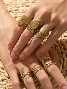 Close-up of 18k gold plated ring set with snake, olive leaf, and skull designs