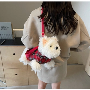 Close-up of Westie puppy plush crossbody bag with red plaid vest on a model