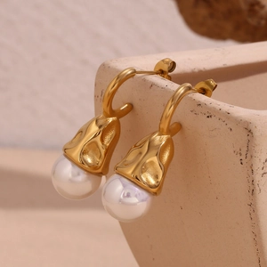 Detail view of 18K gold plated hammered texture earrings with white water drop pearls
