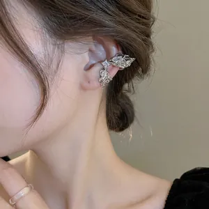 Silver lava style ear cuff with marquise zircons shown on model's ear in close-up