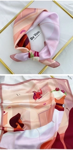 Close-up of elegant square silk scarf with modern city illustration and vibrant warm tones