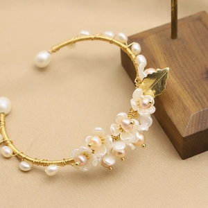 Handmade gold floral cuff with fresh water pearls and delicate white flowers