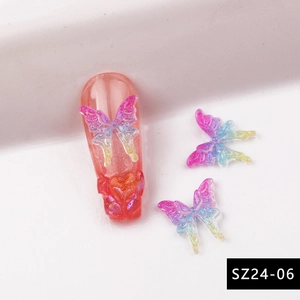 Detail van 3D aurora hars vlinderbedeltjes en hartpatronen op roze kunstnagels