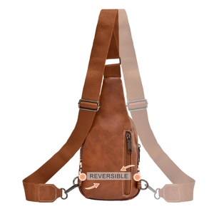 Detail showing the reversible function and adjustable strap of the brown canvas sling bag