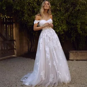 Exquisite lace applique detail on an off-shoulder wedding gown with ethereal tulle skirt