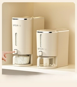 Detail of cream-colored rice dispenser set with push-button and transparent measuring cup
