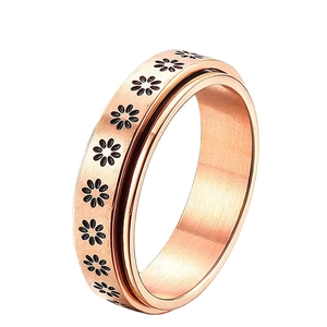 Rose gold spinner fidget ring with brushed finish and black daisy patterns on white base