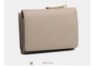 Detail view of light grey leather tri-fold wallet with pebble texture and zipper